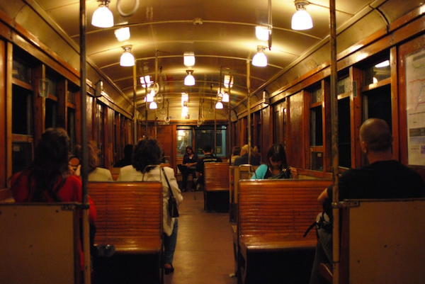 Photo of the interior of an old-style subway, old lamps and wooden seats